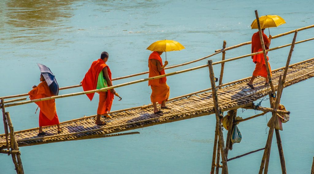 Monks walking across a bridge, Luang Prabang, Laos